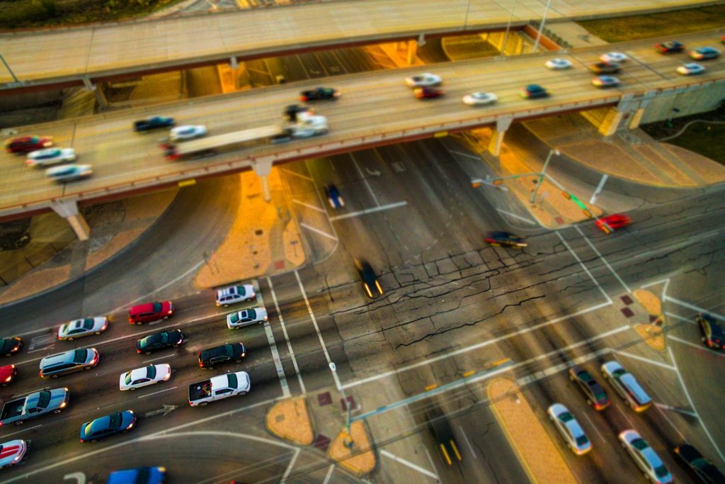 Cars drive on a busy city freeway with an overpass and underpass.